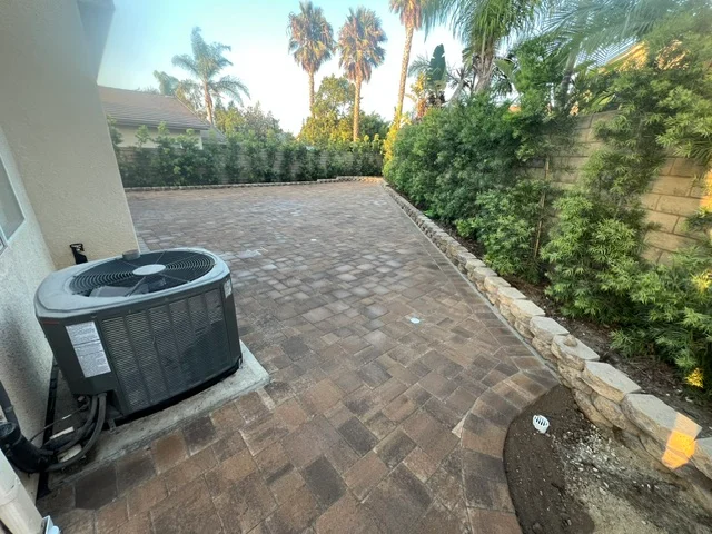 Newly installed brick paver patio with running bond pattern and landscape borders