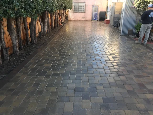 Multi-toned permeable brick pavers installed in running bond pattern on residential driveway