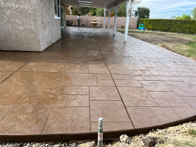 Stamped concrete patio with decorative scoring and earth-tone finish under covered structure