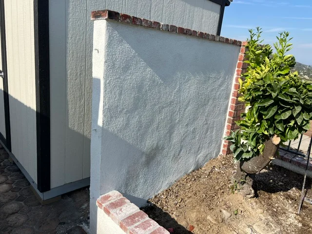 Concrete foundation wall with protective coating and brick trim detail