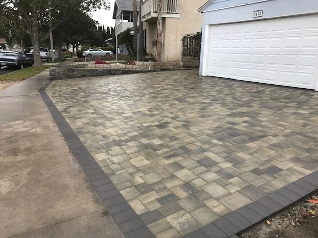 Interlocking concrete paver driveway with geometric pattern and dark border detail