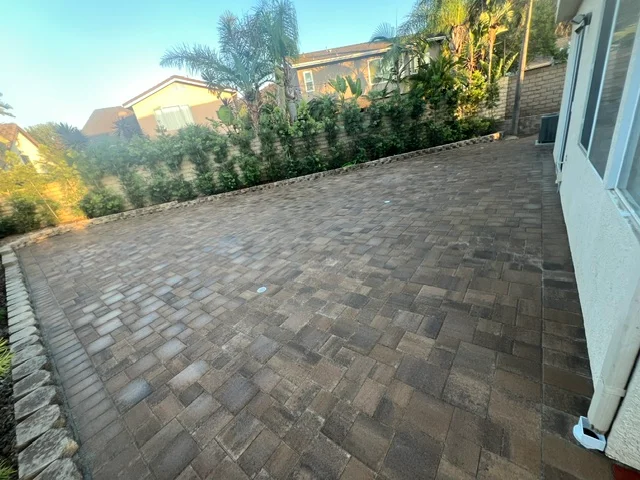 Herringbone pattern permeable pavers in earth tones covering expansive patio area