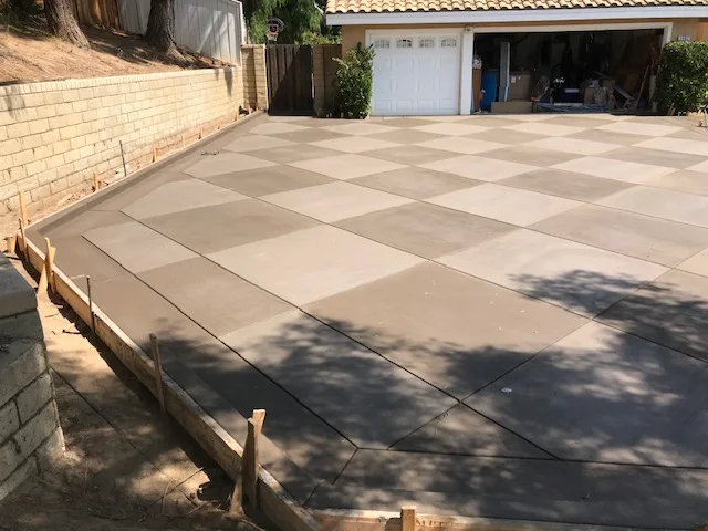 Large format concrete paver driveway with geometric pattern and wooden edge forms