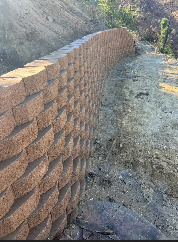 Curved clay brick retaining wall with running bond pattern and concrete cap