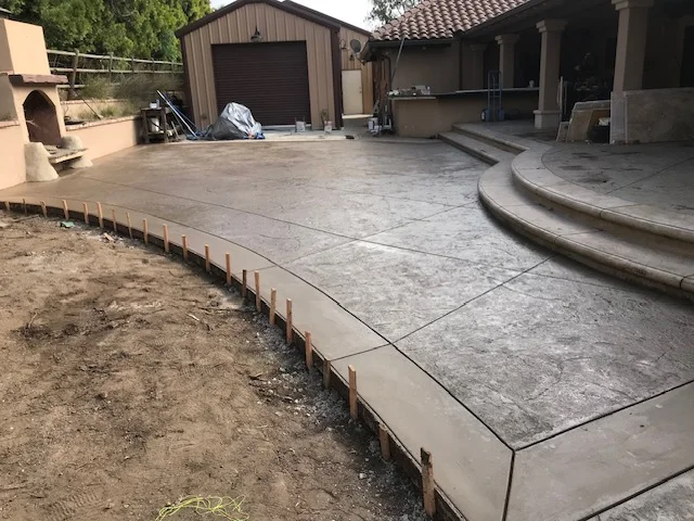 Concrete patio and driveway with control joints and curved seating area under construction