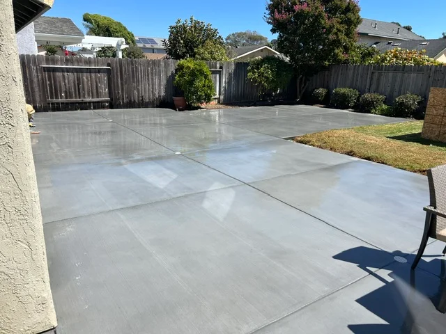 Finished concrete patio with control joints, residential backyard setting