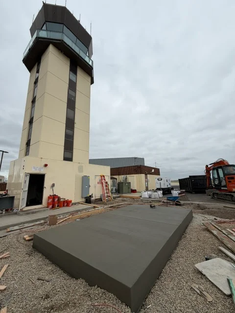Finished concrete pad with smooth trowel finish on gravel base at commercial site