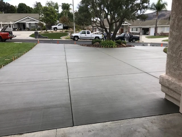 Newly poured concrete driveway with control joints and smooth finish