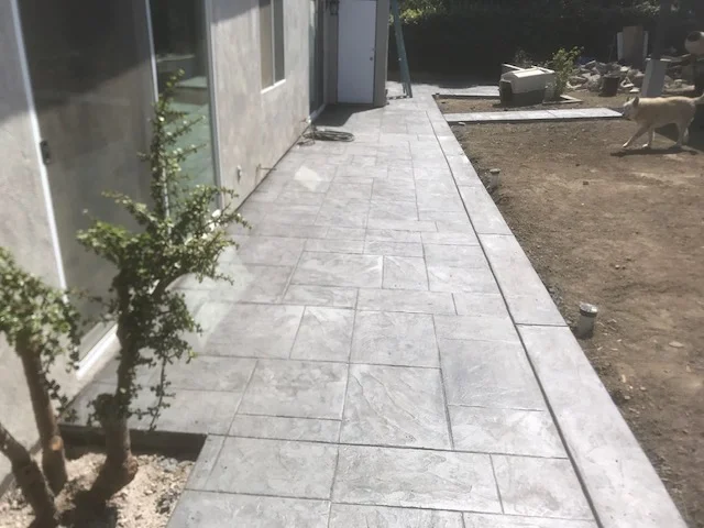 Gray concrete pavers in running bond pattern forming a residential side walkway