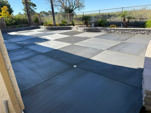 Geometric concrete and paver patio with mixed finishes and landscape borders