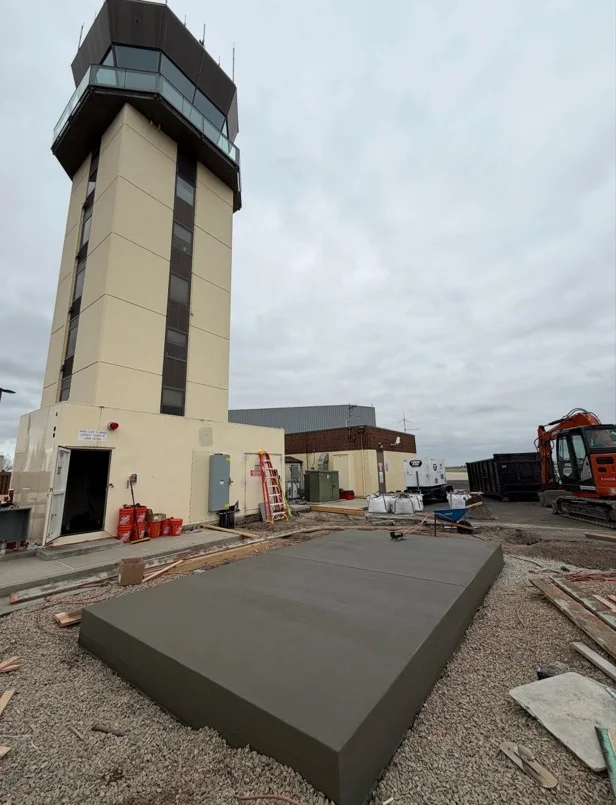 Finished concrete pad with smooth trowel surface at industrial facility with tower structure