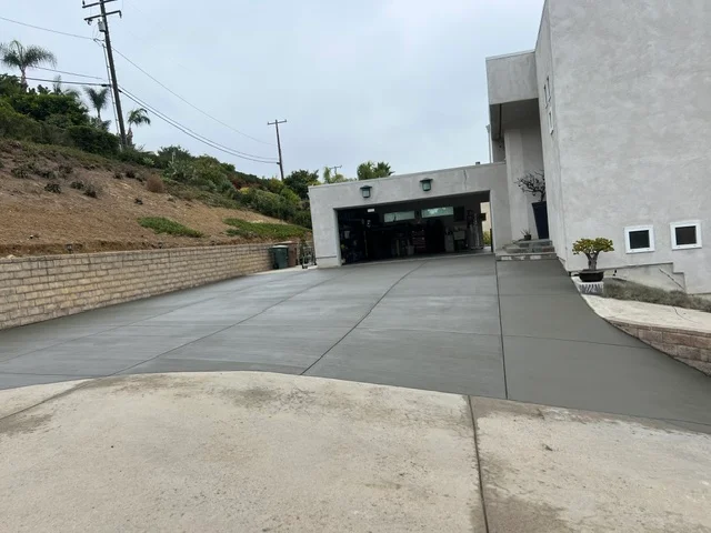 Finished concrete driveway with control joints leading to modern home garage