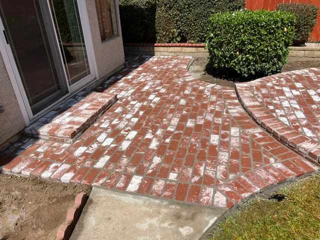 Red and white decorative brick patio with diamond pattern and curved edges
