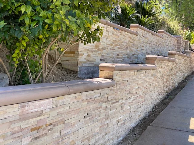 Tiered brick retaining wall with stepped concrete caps and integrated seating