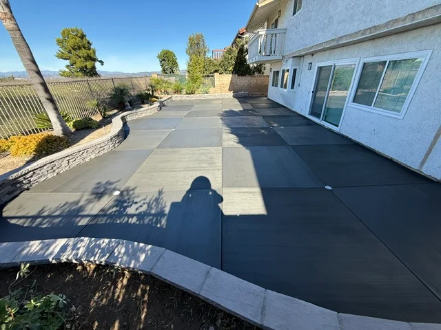 Finished concrete patio with control joints and decorative border adjacent to residential home