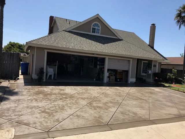 Stamped concrete driveway with slate pattern and control joints in front of residential home