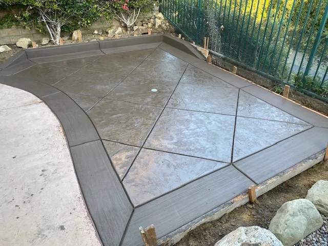Poured concrete patio with geometric scoring patterns and decorative border detail