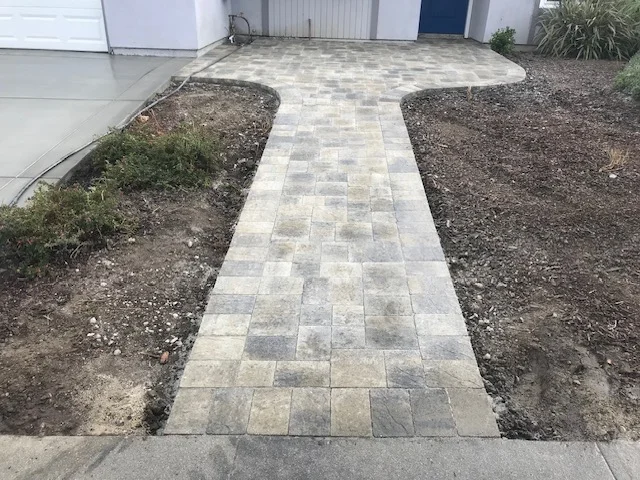 Concrete paver walkway with running bond pattern in gray and tan tones
