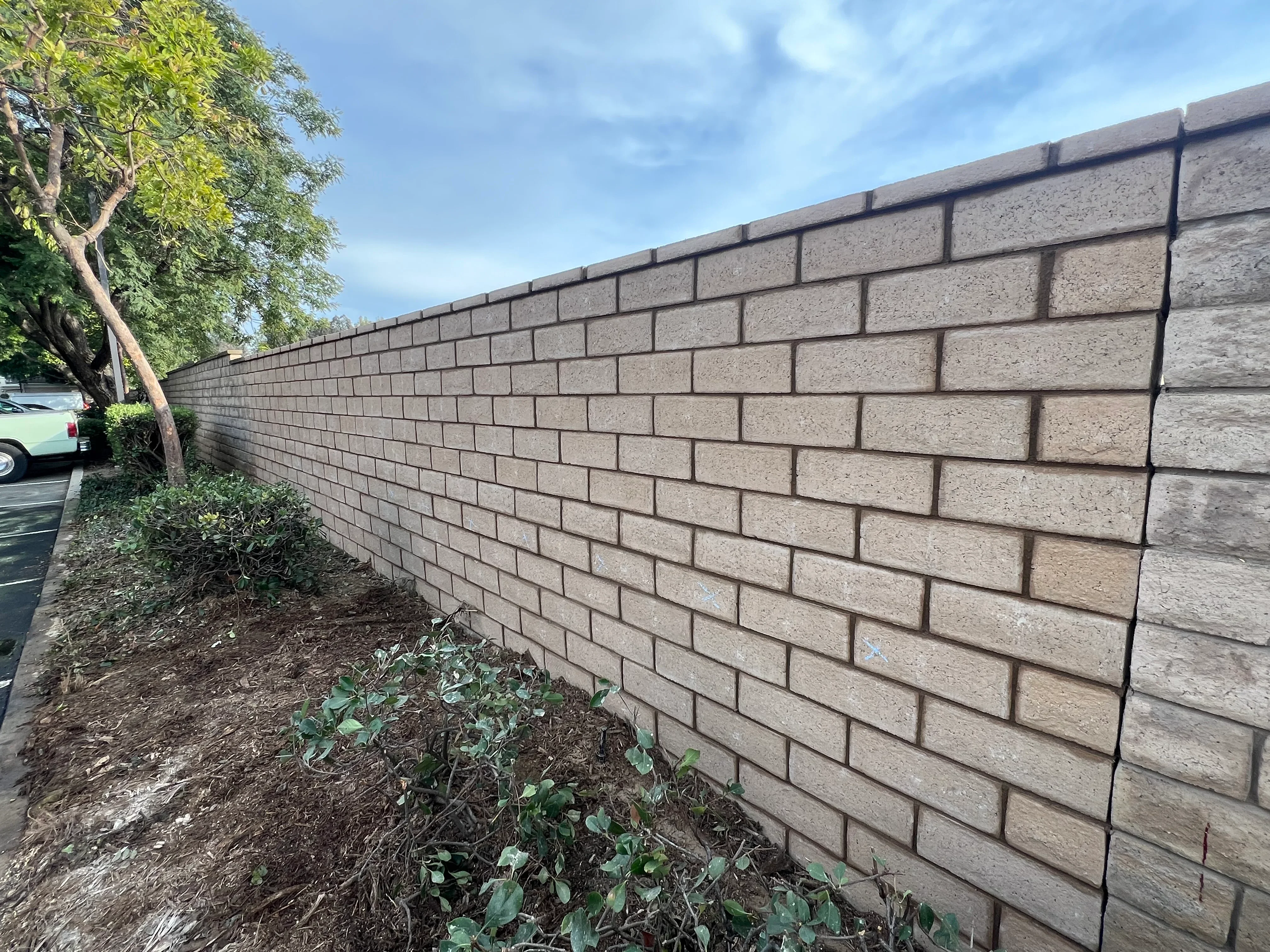 Gray concrete block retaining wall with steel reinforcement and finished cap