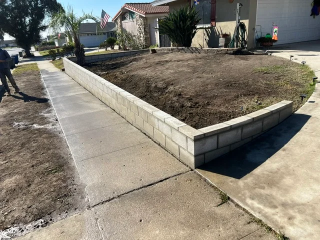 Concrete driveway and concrete block retaining wall with soil fill