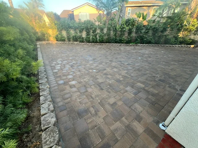 Herringbone patterned permeable paver patio with edging and landscape borders