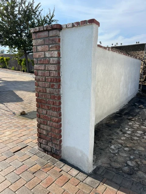 Red brick column with white concrete wall panel on paver foundation