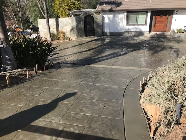 Stamped slate-pattern concrete driveway and patio with control joints and curved edges