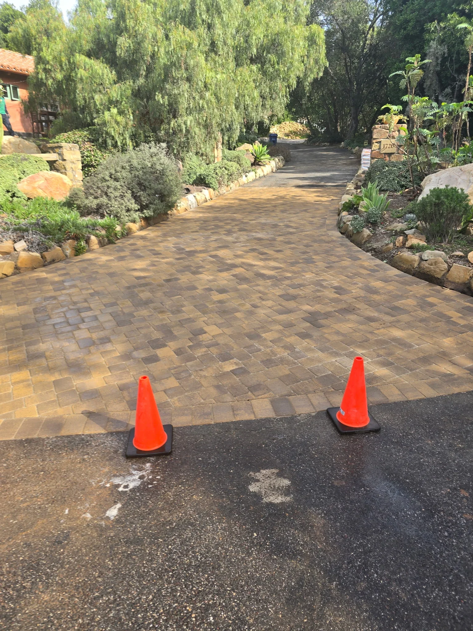 Decorative paver driveway with geometric pattern and natural stone borders