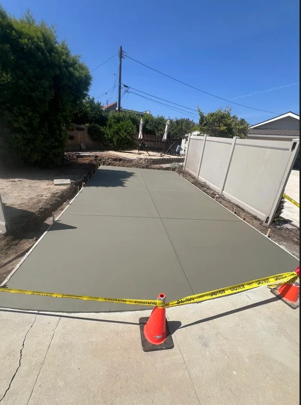 Newly poured concrete driveway with control joints and finished gray surface