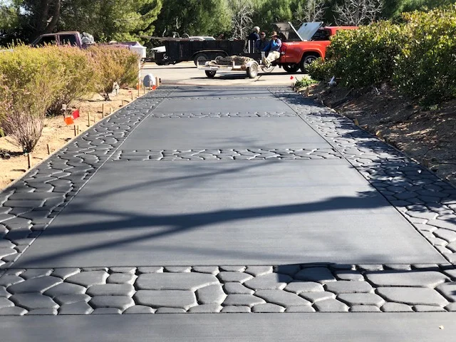 Concrete driveway with smooth center and stamped decorative borders on both sides