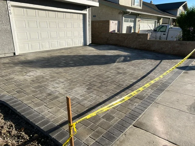 Charcoal permeable pavers installed in running bond pattern on residential driveway