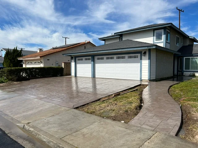 Stamped concrete driveway with brown slate pattern and curved landscape edging