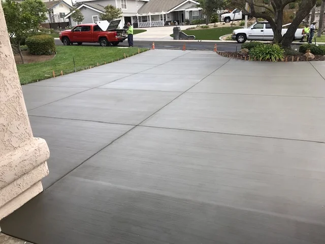 Newly poured concrete driveway with control joints and smooth finish